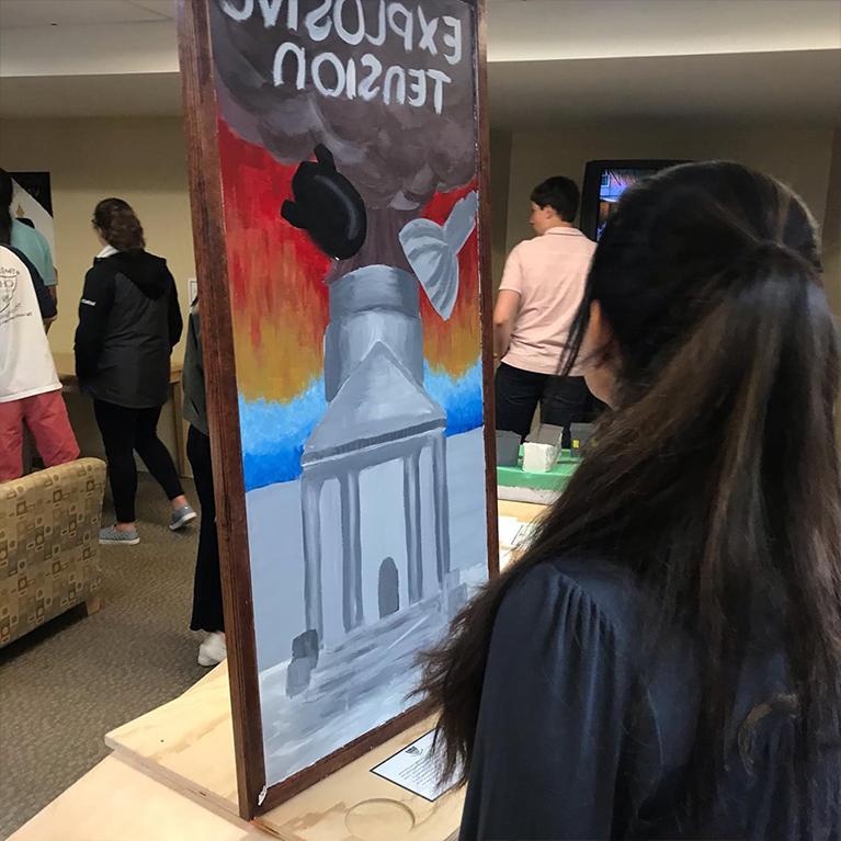 A student looks at a painting at Chase Collegiate.